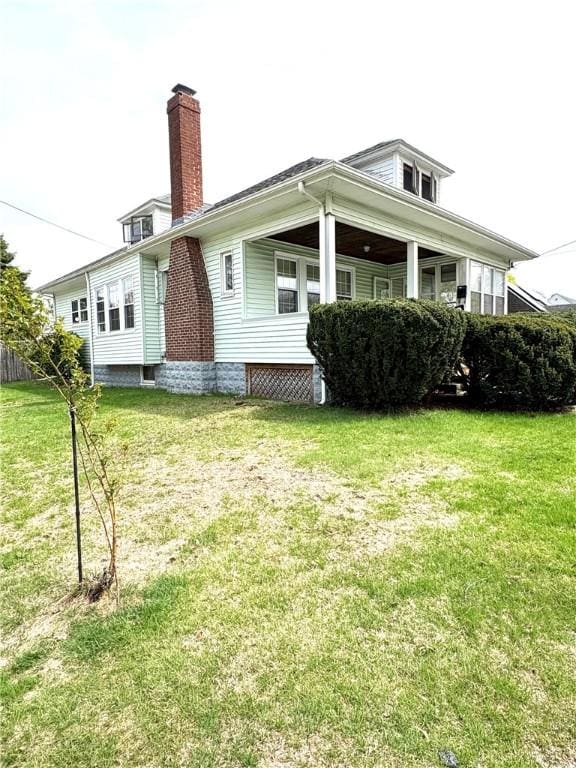back of house with a yard and a chimney