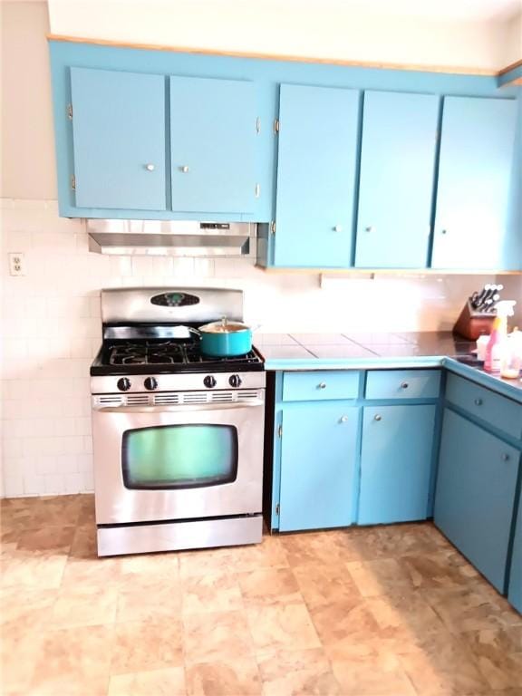 kitchen featuring stainless steel range with gas cooktop, blue cabinets, and under cabinet range hood