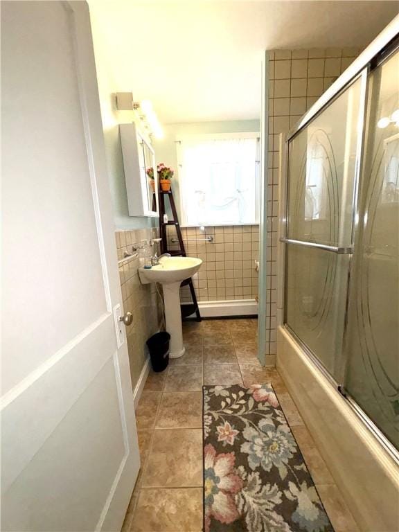 full bathroom with tile walls, shower / bath combination with glass door, and tile patterned floors