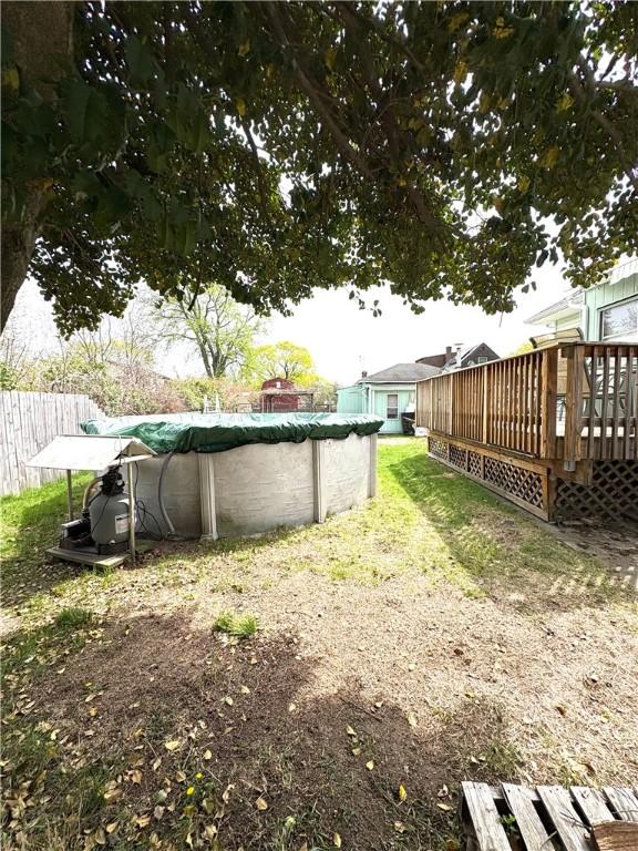 view of yard featuring a deck and a covered pool