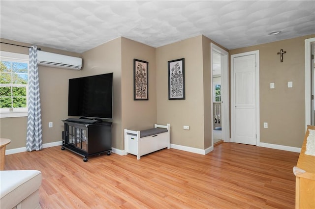 745 Eagle Peak Rd, Burrillville, RI 02859 - living area with an AC wall unit, light wood-type flooring, and baseboards