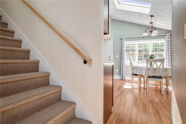 745 Eagle Peak Rd, Burrillville, RI 02859 - staircase with a skylight, wood finished floors, vaulted ceiling, and a chandelier