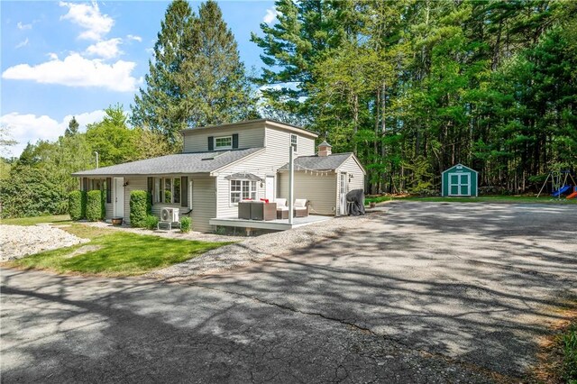 745 Eagle Peak Rd, Burrillville, RI 02859 - view of front of home featuring a storage unit, an outdoor structure, an outdoor living space, a chimney, and roof with shingles