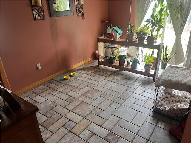 dining area featuring baseboards and stone tile flooring