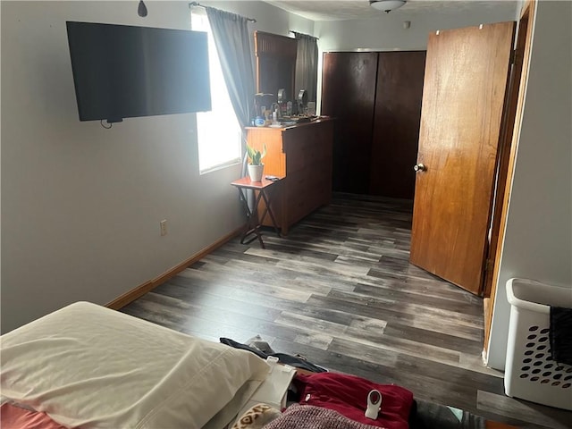 bedroom with baseboards and wood finished floors