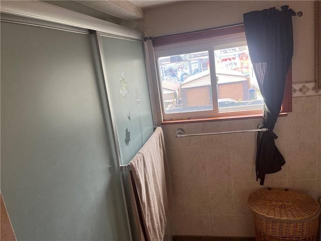 full bathroom featuring a stall shower and a healthy amount of sunlight