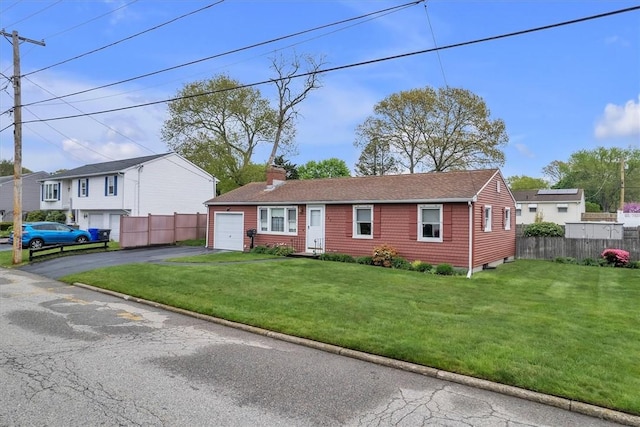 ranch-style home with fence, driveway, a garage, a front lawn, and a chimney