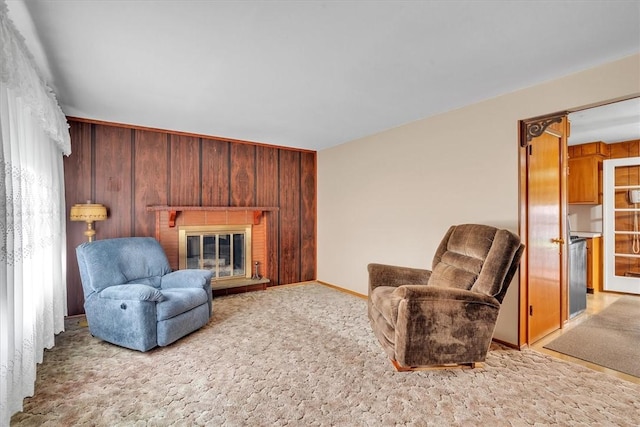 sitting room with a brick fireplace and carpet floors