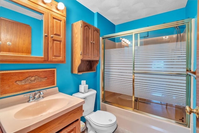 bathroom with enclosed tub / shower combo, vanity, and toilet