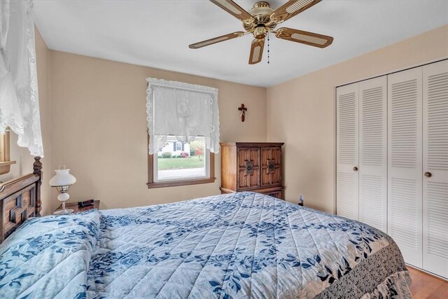 bedroom with a closet, wood finished floors, and a ceiling fan