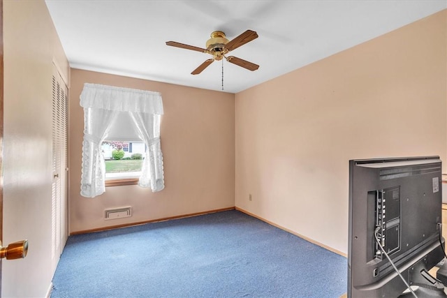 carpeted spare room featuring a ceiling fan and baseboards