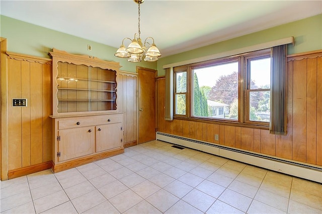 unfurnished dining area with a baseboard radiator, wooden walls, and a notable chandelier