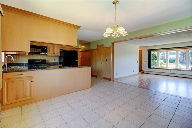 kitchen featuring a sink, a peninsula, a baseboard heating unit, black appliances, and backsplash