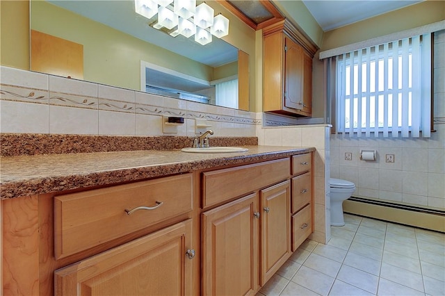 full bathroom with tile walls, a baseboard heating unit, toilet, tile patterned flooring, and vanity
