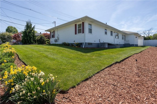 view of home's exterior featuring fence and a lawn