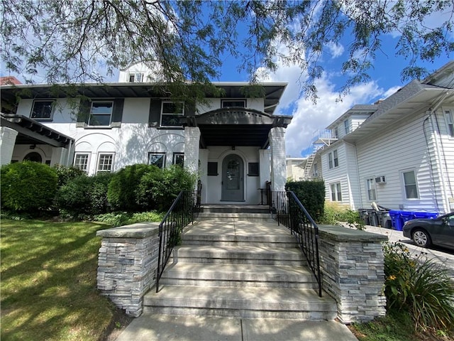 view of front of house with stucco siding and a front yard