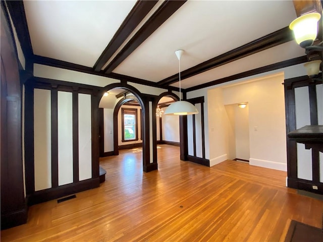 404 Lloyd Ave Unit 408, Providence, RI 02906 - unfurnished living room featuring wood finished floors, baseboards, arched walkways, and beam ceiling