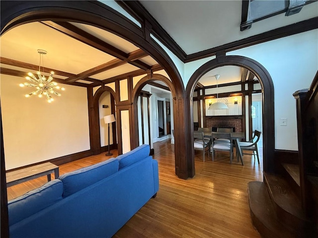 404 Lloyd Ave Unit 408, Providence, RI 02906 - living area with arched walkways, a chandelier, a fireplace, wood finished floors, and coffered ceiling