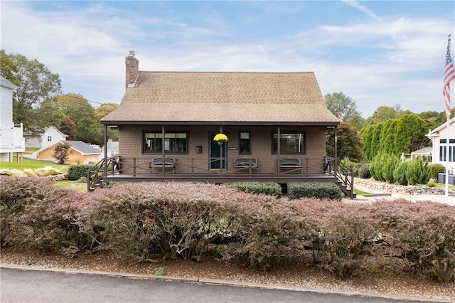 82 Uzzi Ave, Westerly, RI 02891 - view of front facade featuring covered porch, roof with shingles, and a chimney