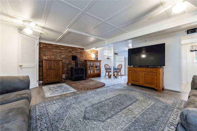 82 Uzzi Ave, Westerly, RI 02891 - living room featuring wood finished floors, a wood stove, ornamental molding, a ceiling fan, and baseboards