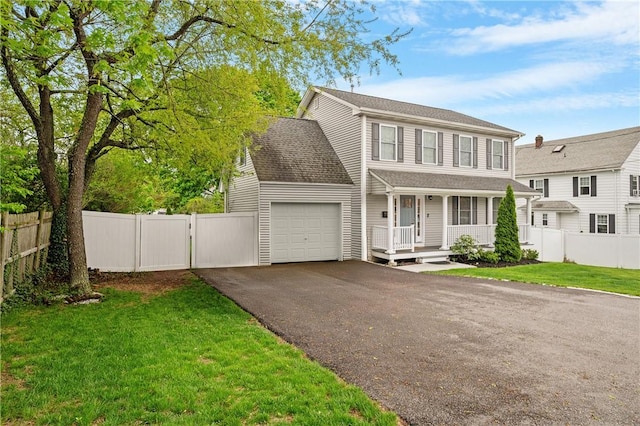 view of front of home featuring a garage, a porch, asphalt driveway, and a gate