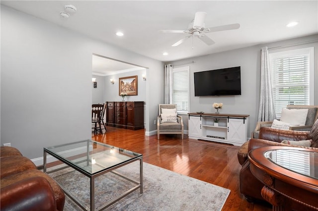 living area with healthy amount of natural light, ceiling fan, wood finished floors, recessed lighting, and baseboards
