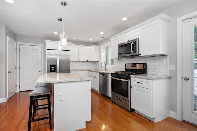 kitchen featuring appliances with stainless steel finishes, a sink, healthy amount of natural light, backsplash, and recessed lighting