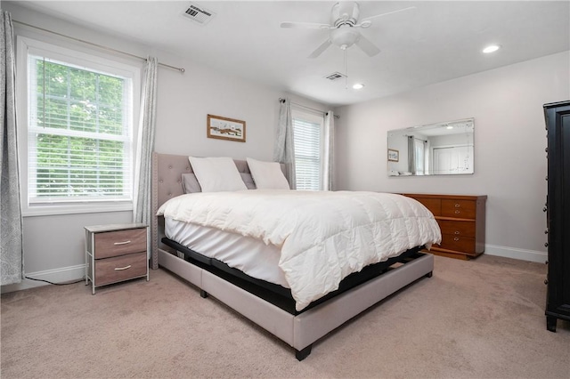 bedroom with multiple windows, light colored carpet, baseboards, and recessed lighting