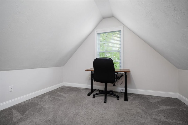 carpeted office featuring lofted ceiling and baseboards