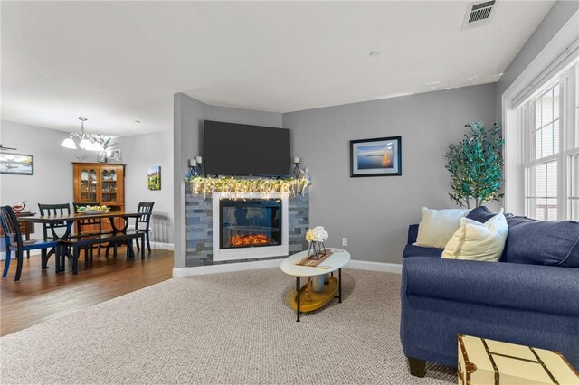 40 Saw Mill Dr Unit 203, North Kingstown, RI 02852 - living room featuring a chandelier, carpet flooring, a glass covered fireplace, and baseboards