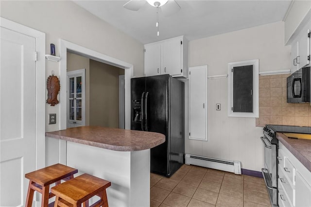 kitchen featuring black appliances, baseboard heating, a ceiling fan, white cabinetry, and a peninsula