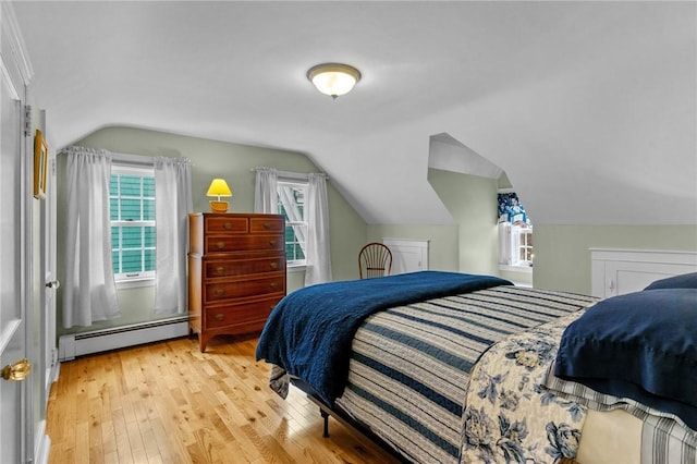 bedroom with a baseboard radiator, vaulted ceiling, light wood-type flooring, and multiple windows