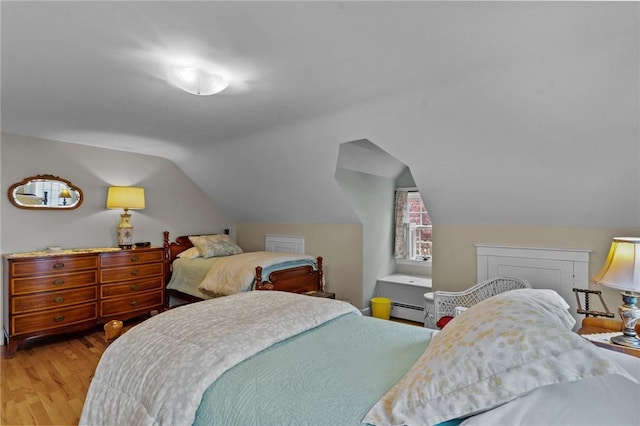 bedroom featuring wood finished floors, vaulted ceiling, and baseboard heating