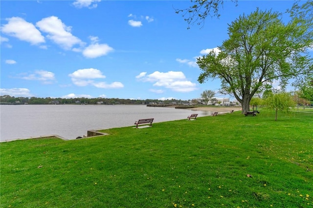 view of green lawn featuring a water view