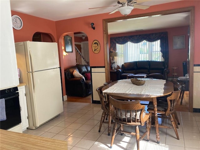 30 Charles St, Cranston, RI 02920 - dining space with light tile patterned flooring, a ceiling fan, wainscoting, and arched walkways
