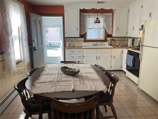 30 Charles St, Cranston, RI 02920 - kitchen with range with gas stovetop, freestanding refrigerator, a baseboard heating unit, a sink, and light countertops