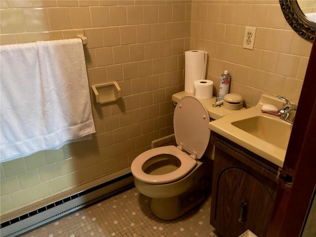 30 Charles St, Cranston, RI 02920 - half bathroom featuring tile walls, a baseboard radiator, toilet, vanity, and tile patterned flooring