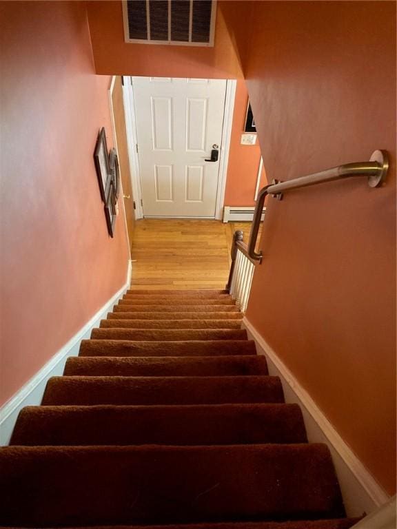 30 Charles St, Cranston, RI 02920 - staircase with baseboard heating, wood finished floors, and baseboards