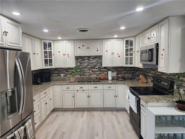 8 Marigold Ct, Cranston, RI 02920 - kitchen featuring appliances with stainless steel finishes, a sink, decorative backsplash, light wood-type flooring, and glass insert cabinets