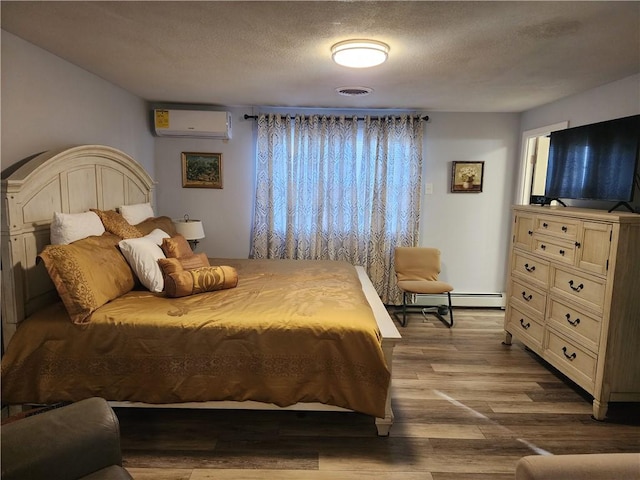 8 Marigold Ct, Cranston, RI 02920 - bedroom featuring a wall mounted AC, a textured ceiling, dark wood finished floors, and baseboard heating