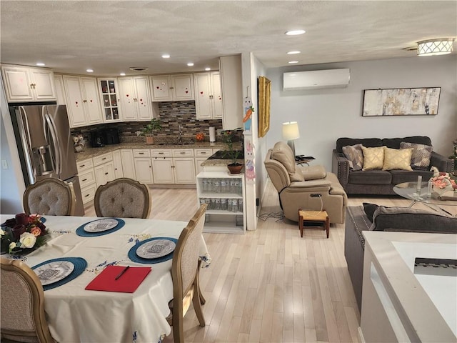 8 Marigold Ct, Cranston, RI 02920 - kitchen with stainless steel fridge, a wall unit AC, open floor plan, light wood-style flooring, and a sink