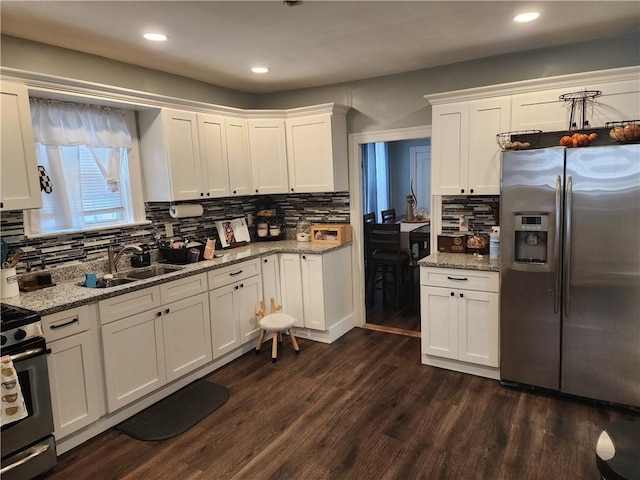 64 Westwood Ave, Cranston, RI 02905 - kitchen featuring appliances with stainless steel finishes, a sink, dark wood-style floors, white cabinetry, and tasteful backsplash