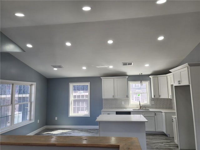 68 Westwood Ave, Cranston, RI 02905 - kitchen with a sink, decorative backsplash, wood finished floors, light countertops, and a center island