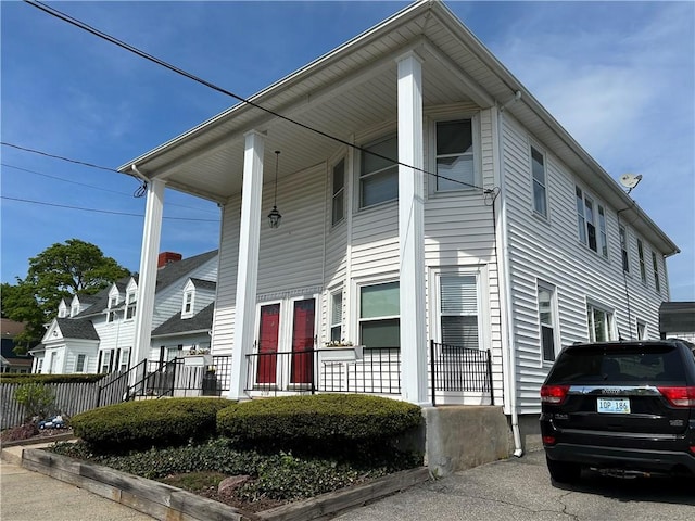 view of front of home featuring covered porch and fence