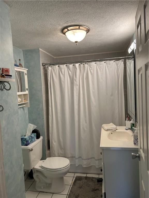 full bathroom featuring toilet, a textured ceiling, tile patterned floors, shower / bath combination with curtain, and vanity
