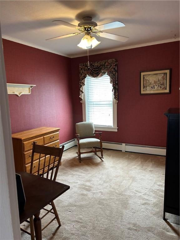 sitting room with carpet flooring, baseboards, crown molding, ceiling fan, and a baseboard heating unit