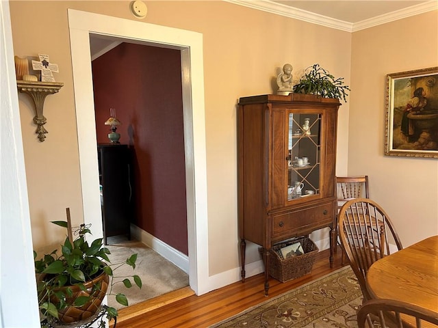 dining area with ornamental molding, baseboards, and wood finished floors