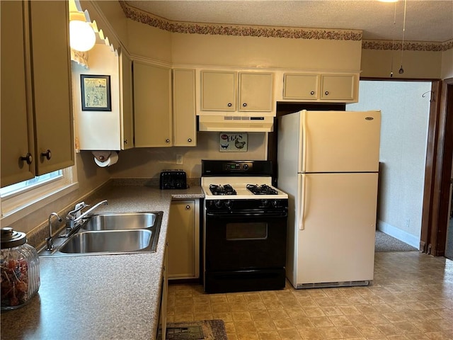 kitchen with freestanding refrigerator, gas stove, under cabinet range hood, and a sink