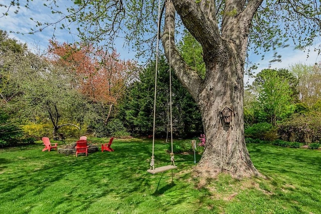 view of play area featuring a lawn and a fire pit