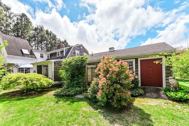 back of property with a lawn and a chimney